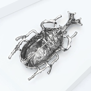 Detail view of the beetle brooch back showing the secure silver metal pin clasp