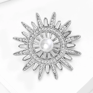 Vue détaillée d'une broche soleil en argent avec grande perle blanche et zircons brillants