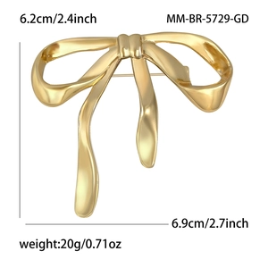 Elegant golden alloy ribbon bow brooch with polished finish and secure safety pin back