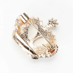 Exquise broche couronne dorée en strass vue de dos avec fermeture à épingle sur fond blanc