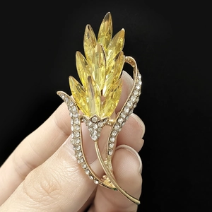 Vue détaillée d'une broche épi de blé avec cristaux jaunes et placage d'or élégant