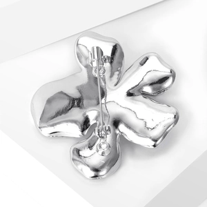 Detailed macro view of the polished silver floral brooch back with secure safety clasp