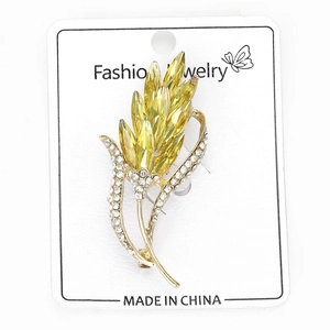 Détail d'une broche en forme d'épi de blé avec cristaux jaunes et petits zircons blancs