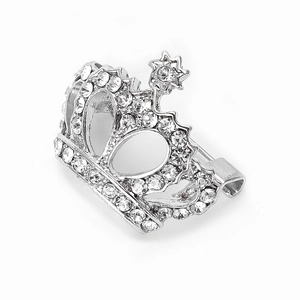 Détail d'une broche couronne argentée ornée de strass brillants et d'une étoile