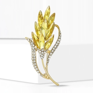 Broche blé dorée élégante avec cristaux jaunes et strass blancs brillants sur fond blanc