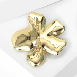 Detailed back view of the golden floral brooch showing the pin clasp and polished finish