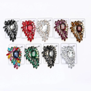 Detailed macro display of vintage alloy brooches with large colorful crystals and rhinestones