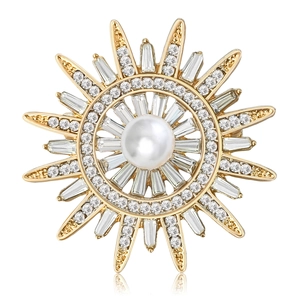 Élégante broche soleil dorée avec perle centrale et strass baguette scintillants