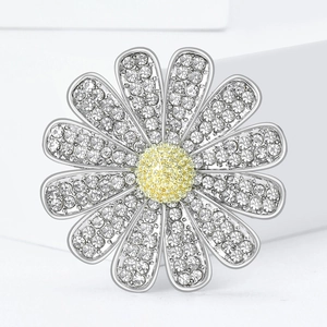 Elegante spilla a forma di margherita con strass bianchi brillanti e centro giallo su bianco
