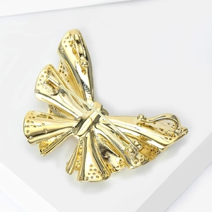 Detailed back view of a golden butterfly brooch showing the secure pin fastener structure