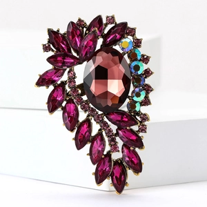Detailed close-up of vintage gold alloy brooch with red and pink rhinestone crystals