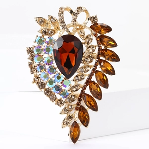 Detail of vintage gold brooch featuring amber teardrop gem and shimmering crystal accents