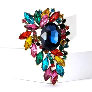 Detailed close-up of a vintage colorful crystal brooch with a deep blue oval centerpiece