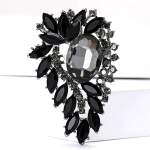 Close-up of vintage rhinestone brooch with grey oval stone and black crystals