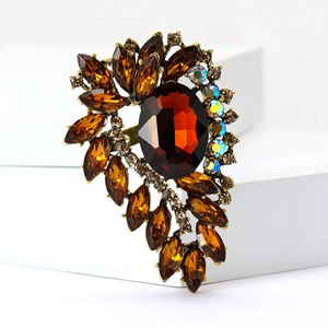 Detail of vintage bronze brooch with large oval amber gemstone and sparkling crystals