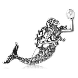 Vintage silver mermaid brooch with white pearl accent on a reflective white background