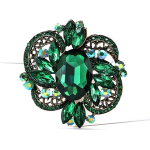 Macro shot of vintage emerald crystal brooch with gold hollowed metal filigree