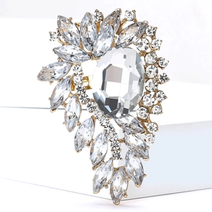 Macro shot of luxury gold brooch featuring large oval crystal and marquise rhinestones