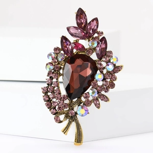 Detailansicht einer Vintage Blumenbrosche mit lila Kristallen und bernsteinfarbenem Stein