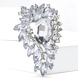 Detailed macro shot of vintage alloy leaf brooch with brilliant rhinestones on white block