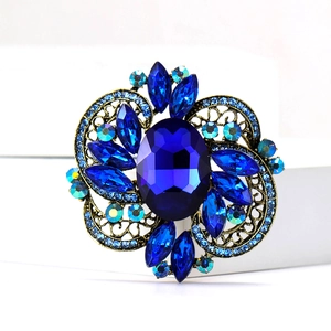 Detailed view of vintage gold brooch with blue gemstones and filigree patterns