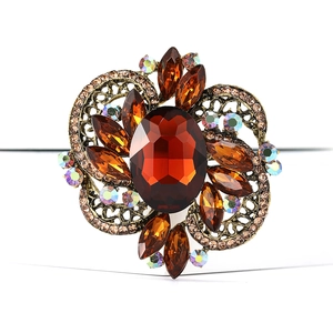 Macro detail of vintage brooch featuring large amber resin stone and rhinestone accents