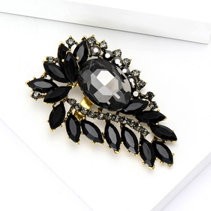 Detailed view of luxury vintage brooch with grey crystals on golden alloy base