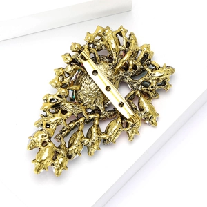 Detailed back view showing the intricate filigree metalwork and secure pin of the brooch