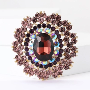 Detailed macro view of vintage round brooch with red gemstone and colorful crystals