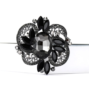 Macro shot of vintage gothic flower brooch with black oval gemstone and crystal petals