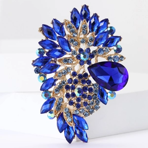 Macro shot of luxury blue marquise and teardrop crystal brooch with golden base