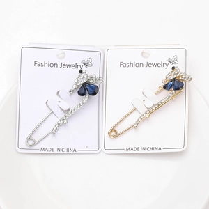 Détail de broches cygne en argent et or avec cristaux bleus et strass étincelants