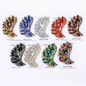 Macro detail of alloy feather brooches with teardrop glass gems in nine color variants