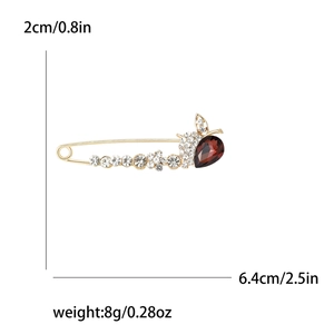 Broche dorée élégante avec cristaux dégradés et pierre rouge en forme de goutte