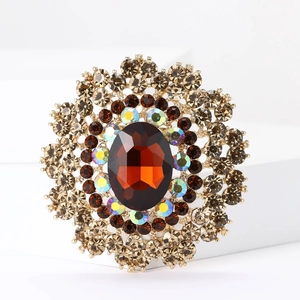 Macro shot of vintage round alloy brooch with brown crystal and radial rhinestone layers