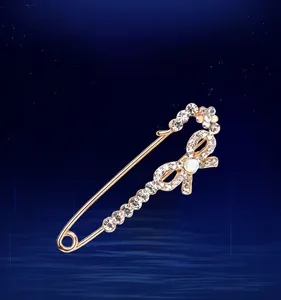 Détail d'une grande broche en cristal doré avec design de nœud sur fond bleu foncé