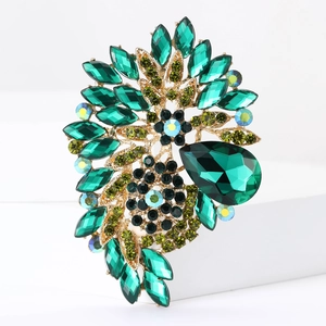 Detailed macro view of an emerald green crystal flower brooch with golden alloy setting