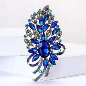 Detail einer Vintage-Brosche mit großem blauem Kristall und Marquise-Strasssteinen