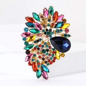 Detailed macro shot of a large golden brooch with vibrant multicolor rhinestones