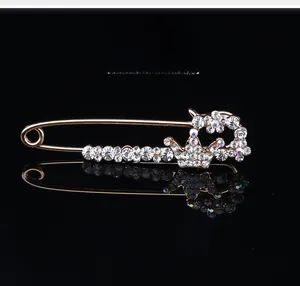 Vue détaillée d'une broche couronne en cristal doré avec reflet sur fond noir poli