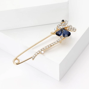Vue détaillée d'une broche papillon en cristal avec ailes bleues et finition dorée