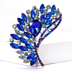 Macro shot of vintage gold alloy fan brooch with pear-cut blue crystals and rhinestones