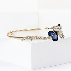 Vue détaillée d'une broche paon avec cristaux bleus en forme de goutte et strass blancs