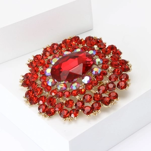 Vintage gold alloy flower brooch with large red crystal and sparkling rhinestones