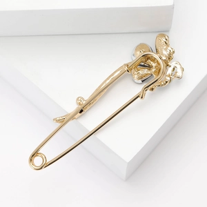 Broche paon élégante en or avec strass en cristal sur un support d'affichage minimaliste