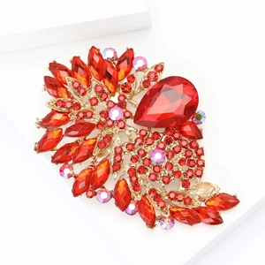 Vintage gold-tone alloy flower brooch with deep red rhinestones on white display