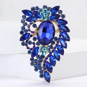 Macro shot of vintage gold alloy brooch with large oval navy blue crystal and rhinestones