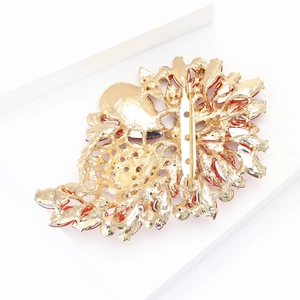 Detail view of the gold alloy brooch back featuring fine hollow patterns and secure pin clasp