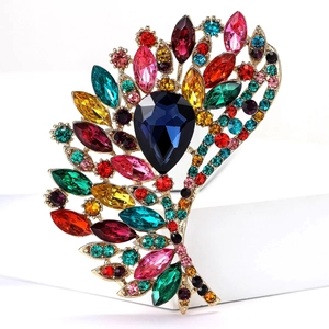 Macro detail of high-end gold brooch with colorful gemstones and teardrop blue stone