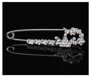 Vue détaillée de la broche épingle de nourrice couronne argentée avec des strass brillants